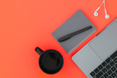 Çalışma alanı. Modern dizüstü, beyaz kulaklık, gri defter ile bir kalem ve bir fincan kahve kırmızı arka plan ve metin, yukarıdan bir görünüm için bir yer. Flatlay.Copyspace.