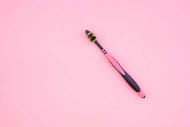 Ttoothbrush pembe bir arka plan, yukarıdan bir görünümü var. Boşaltmak. Düz yatıyordu. Diş Bakımı kavramı.