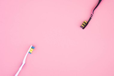 İki diş fırçaları boşaltmak, pembe bir arka plan yalıtılır. Düz yatıyordu. Diş Bakımı kavramı.