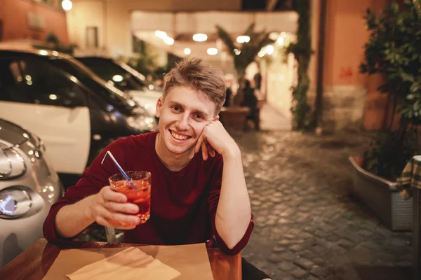 Портрет Улыбающегося Молодого Человека Сидящего Вечернем Ресторане Стаканом Алкоголя Руках — стоковое фото