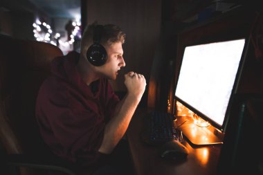 Oyunu izlerken ve tezahürat bilgisayar ekranında oyun görünüyor duruldu. Ciddi genç adam video evde bir bilgisayarda, cyber spor oyunlarını.