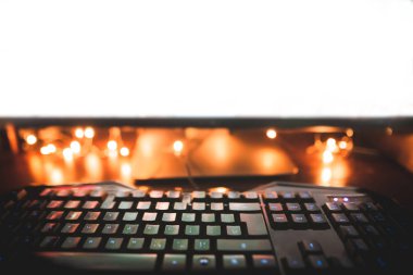 Arka plan. Klavye, fare ve bilgisayar monitörü sıcak aydınlatma ile gece. Gece bilgisayar işyerinde. Boşaltmak. Oyun arka plan