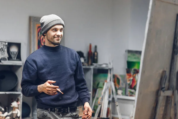 Joven Feliz Estudio Arte Con Pincel Las Manos Mirando Lienzo — Foto de Stock