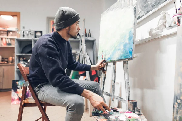 Bir sanatçı öğrenci sınıf ve bir resim tuval üzerine boya portresi. Sanat Okulu, eğitim. Adam boyama öğrenir.