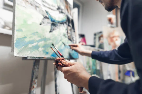 专业艺术家在画布上画油画 手与画笔关闭和焦点 坐在工作室里的有创造力的人创造了一幅画 绘画作为一种爱好和生意 — 图库照片