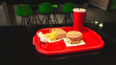 Hamburger, patates kızartması ve kırmızı bir içecek fast food restoran cam. Fast food fast food restoran vasıl tablo tepsi menüsünde. Fast Food kavramı.