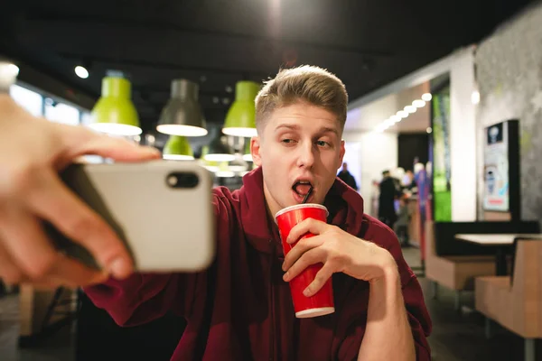 Grappige Tiener Een Cola Drinkt Uit Een Rode Glas Vormt — Stockfoto