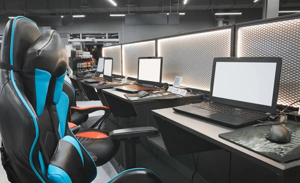 Gaming space with a chair and a laptop in a store technology. Professional equipment for cybersport. Buying a gaming laptop, headphones, mouse and armchairs. Gaming equipment concept.