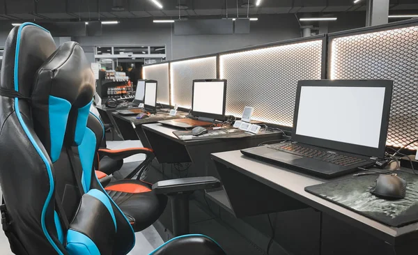 Bir sandalye ve bir dizüstü bilgisayar mağaza teknoloji ile oyun alanı. Profesyonel ekipman cybersport için. Satın alma bir oyun dizüstü bilgisayar, kulaklık, fare ve koltuklar. Oyun ekipmanları kavramı.