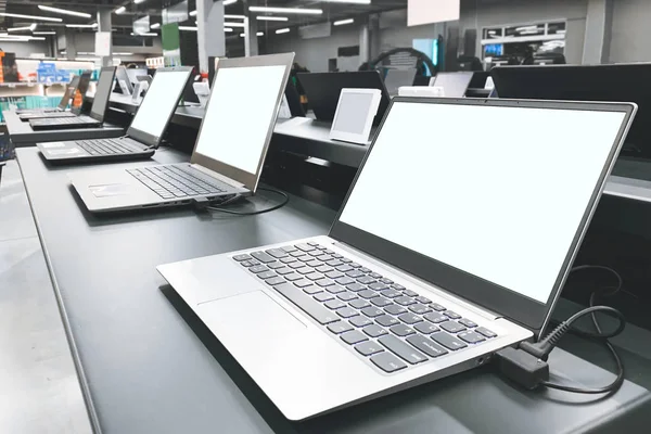 Department of laptops in the electronics store. Table showcase with laptops in the technology store. Choosing and buying a laptop in a technology store.