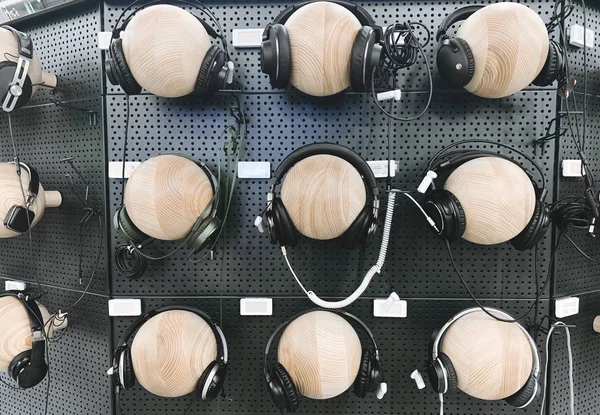 ガジェット ストア内の壁に多くのヘッドフォン 選択して 技術のストアの音楽部門でヘッドフォンを購入します バック グラウンド — ストック写真