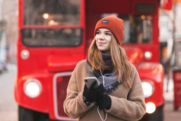 Χαμογελαστά Νεαρή Γυναίκα Ζεστά Ρούχα Και Ένα Smartphone Στα Χέρια — Φωτογραφία Αρχείου