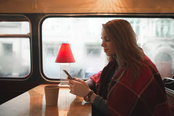 Schöne Mädchen Sitzt Einem Gemütlichen Café Mit Einer Decke Bedeckt — Stockfoto