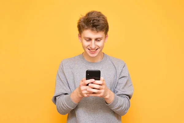 Retrato Tipo Feliz Pie Sobre Fondo Amarillo Usando Teléfono Inteligente — Foto de Stock