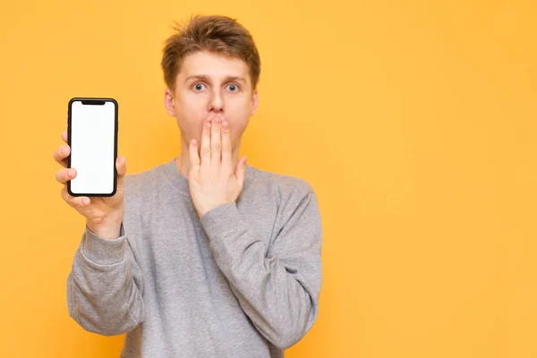 Shocked Young Man Casual Clothing Holds His Hand Modern Smartphone — Stock Photo, Image