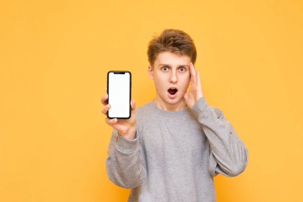 Portrait Surprised Young Man Casual Clothing Holds His Hand Modern — Stock Photo, Image