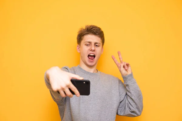 Grappige Kerel Casual Kleding Staat Een Gele Achtergrond Neem Selfie — Stockfoto