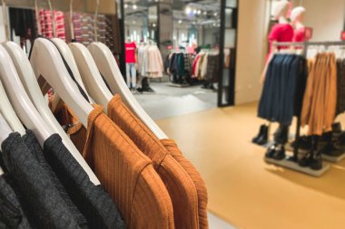 Bulanık arka plan üzerinde elbise askıları ile şık giysiler saklayın. Parlak elbiseler moda mağaza arka plan üzerinde. Alışveriş kavramı. Arka plan. Boşaltmak