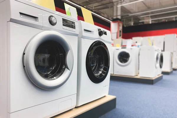 Washing machines are in the household appliance store. Choosing and buying washing machines in the electronics store. Copyspace