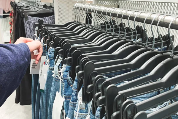 Many Jeans Hangers Clothing Store Woman Chooses Buyer Hands Jeans — Stock Photo, Image