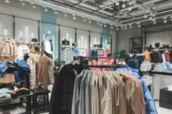 Blurred Background. Stylish modern clothes store without people, interior. Cozy store with stylish clothes, spring-autumn season. Shopping concept