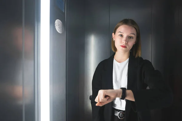 Takım Elbiseli Genç Kadın Işçilerin Saat Asansörde Kontrol Ediyor Dakik — Stok fotoğraf
