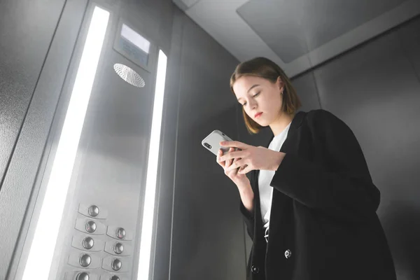 Şçisi Kadın Ofis Asansörde Onun Smartphone Ekranında Arıyor Cep Telefonunu — Stok fotoğraf