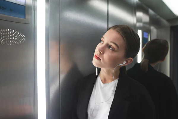 Genç Kadın Memur Kat Numaradan Arıyorsunuz Kulaklık Müzik Dinlemek Asansörde — Stok fotoğraf