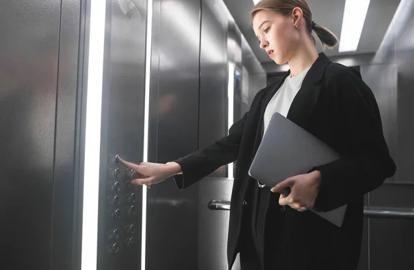 Mujer Negocios Concentrada Presionando Botón Del Ascensor Sosteniendo Portátil Mano — Foto de Stock