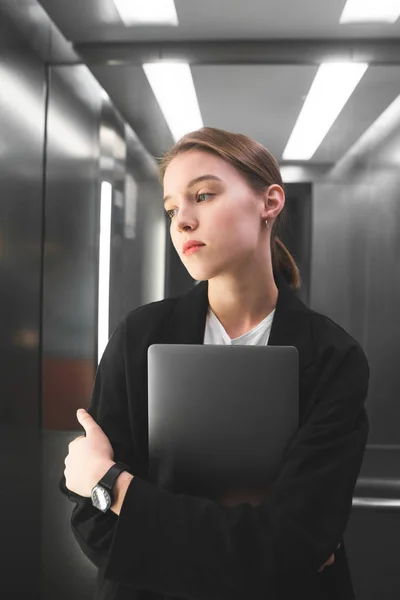 Foto Vertical Una Joven Empresaria Seria Sosteniendo Portátil Ascensor Una — Foto de Stock