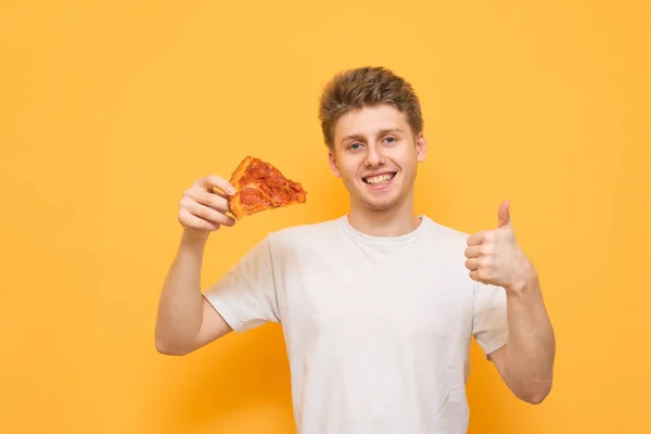 Jovem Feliz Uma Camiseta Branca Segura Pedaço Pizza Apetitosa Suas — Fotografia de Stock