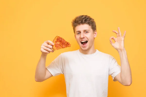 Cara Emocional Com Pedaço Pizza Suas Mãos Mostra Gesto Olha — Fotografia de Stock