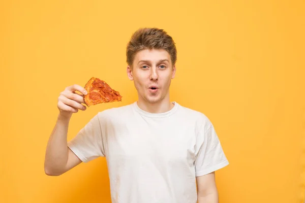 Sorprendido Tipo Divertido Sostiene Pedazo Pizza Sus Manos Mira Cámara — Foto de Stock