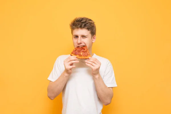 Jovem Bonito Morde Pedaço Pizza Apetitosa Olha Para Câmera Fundo — Fotografia de Stock