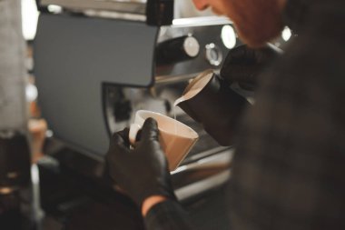Karışımları süt kahve ile sıcak, yakın çekim fotoğraf, profesyonel bir barista cappuccino bir kafede hazırlar. Barista adam bir bardağa süt dökülen ve kahve bir resim yapar. Arka plan