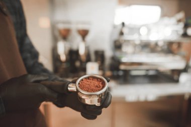 Barista elinde bir sahibi ile taze çekilmiş kahve, yakın tutar. Kafede kahve pişirme. Kahve kültür kavramı. Arka plan