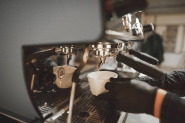 Yakın çekim fotoğraf pişirme süreci bir profesyonel kahve makinesinde kafede kahve, kahve dökülen bir bardağa döker. Barista espresso kahve makinesi bir fincan içine dökülen. Arka plan. Boşaltmak