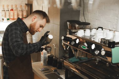 Kahve taneleri dijital ölçek üzerinde ağırlığında. Daha önce bira kahve kahve taneleri bir papercup ve ölçek üzerinde eller erkek barista dökme, kavrulmuş.