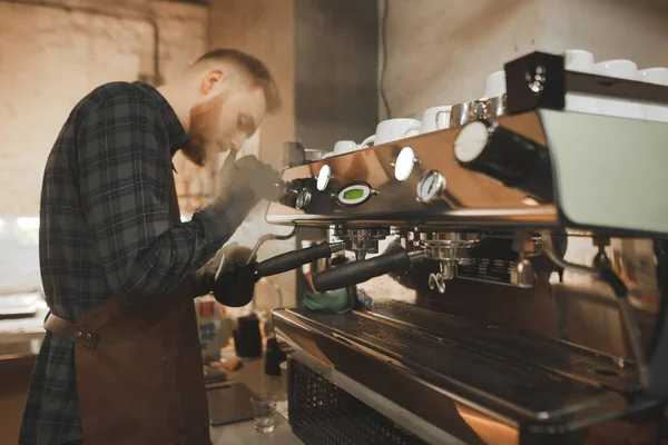 プロのコーヒー マシンで牛乳を蒸すアゴヒゲ バリスタの肖像画 コーヒー ショップのコーヒー マシンでコーヒーを調理のプロセス コーヒー ショップのオーナーを作業します — ストック写真