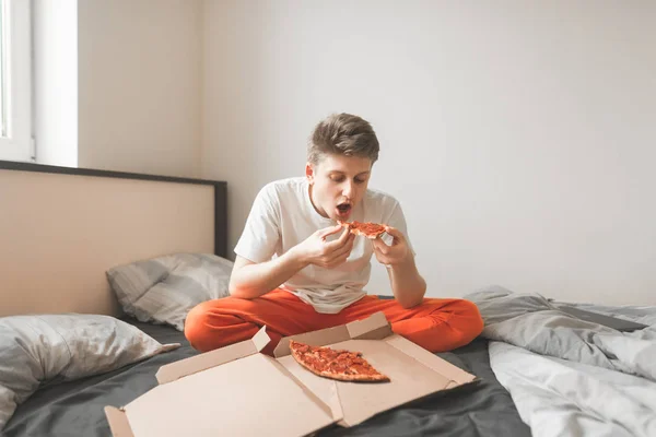 Portrait Young Man Sitting Home Bed Eating Pizza Box Holding — Stock Photo, Image