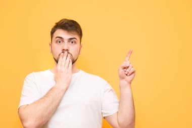 Sarı bir arka plan üzerinde şaşırmış bir adam portresi onun fin gösterir