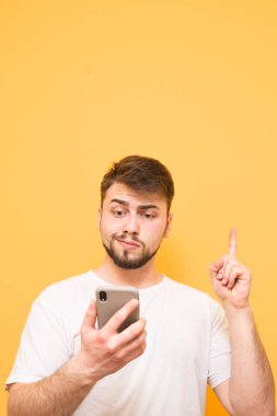 Bir sakallı duygusal adam bir smartphone Haritayı elinde tutar.