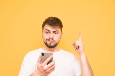 Bir sakallı duygusal adam bir smartphone Haritayı elinde tutar.