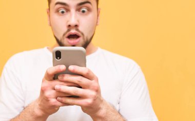 Yakın çekim fotoğraf, bir smartphone vasıl bakarak şok adam. Hayret adam 