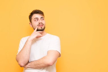 Mutlu adam takıyor bir beyaz T-shirt, standları sarı bir arka plan üzerine bir