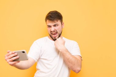 Bir sakallı bir smartphone bir video oyunu oynar, bir WHI giyer