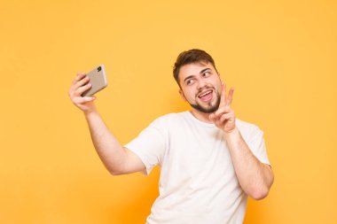 Komik sakallı adam bir beyaz T-shirt üzerinde sarı bir ba selfie alır