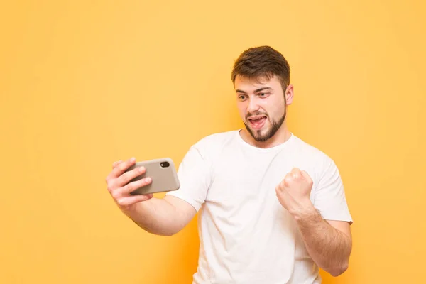 Adult man with a beard playing mobile games on a smartphone, loo — Stock Photo, Image