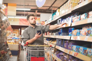 Alıcı bir sepeti ile koridor süpermarket tatlılar departm standları