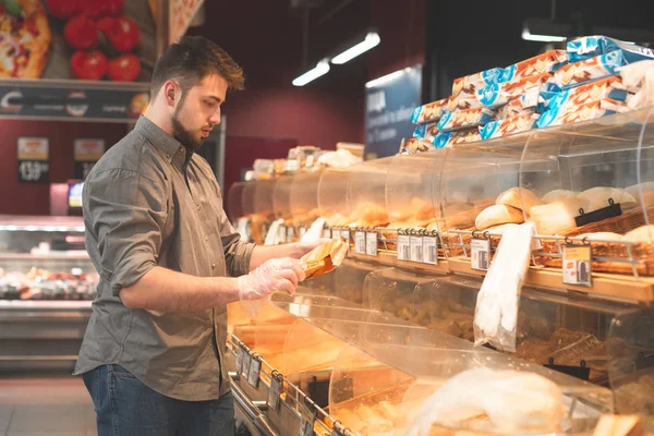 Portrét muže, který si koupí rohlíku v supermarketu se chléb depa — Stock fotografie